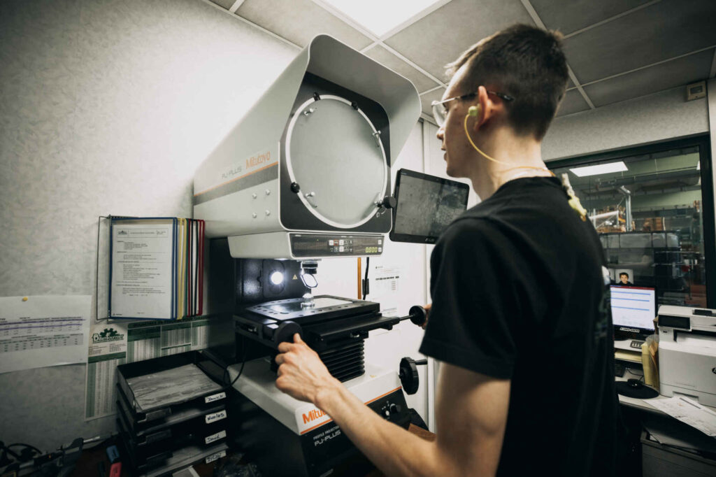photo d'un industriel entrain de faire un contrôle qualité sur une pièce
